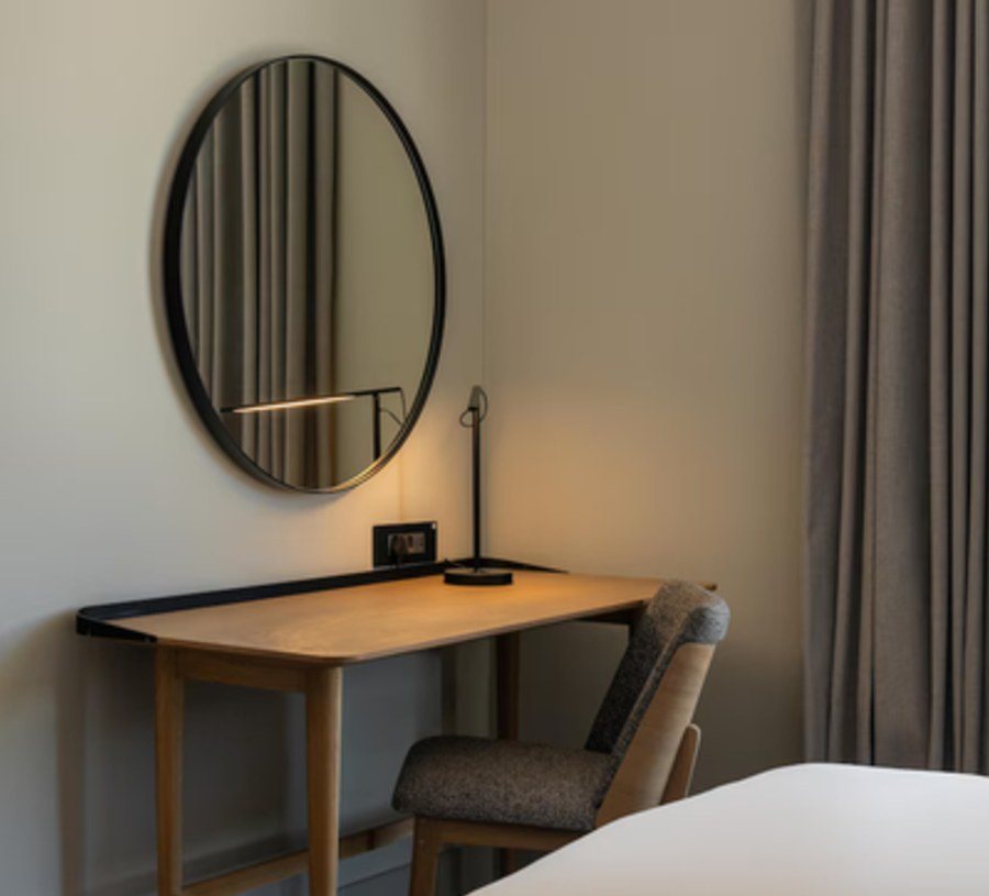 Desk, mirror and task seating in a guest room