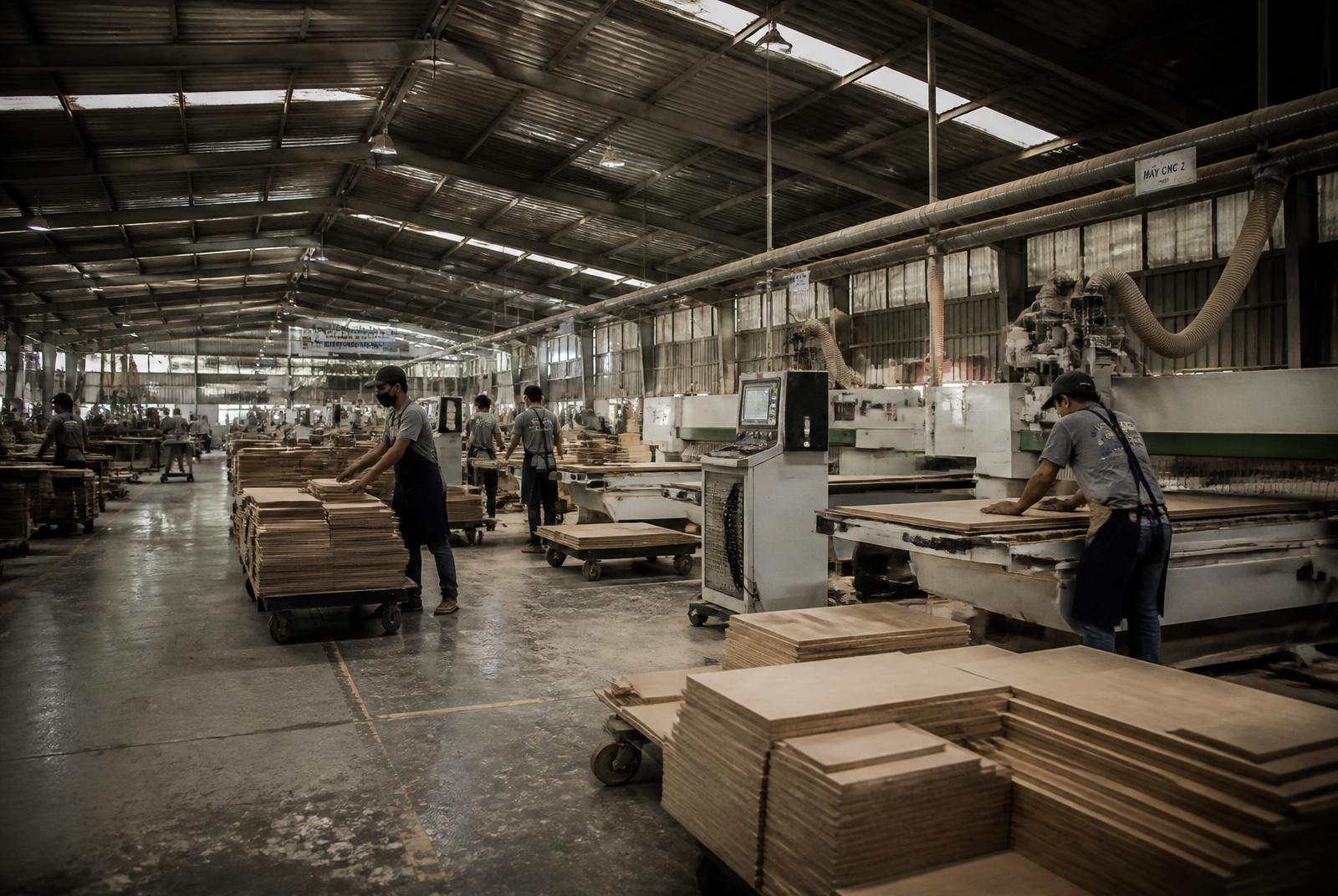 Furniture factory floor with machinery and stacked timber