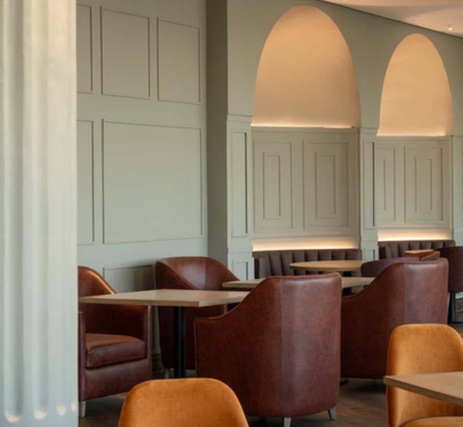 Lounge banquette and armchairs under arched detailing