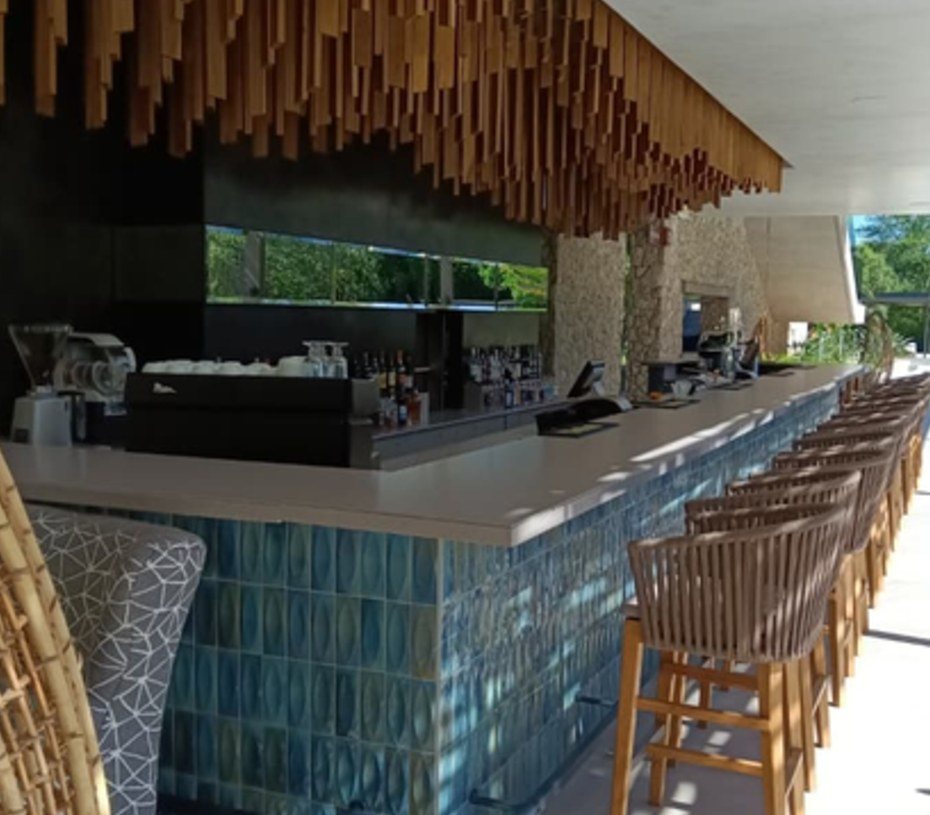 Counterpoint Bar — A full-length service bar: tiled front, seamless work top, timber slat soffit overhead.